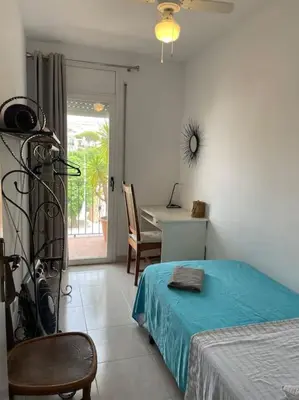a bedroom with a bed and a table and a desk at Preciosa casa en el centro con terraza y patio in Sitges
