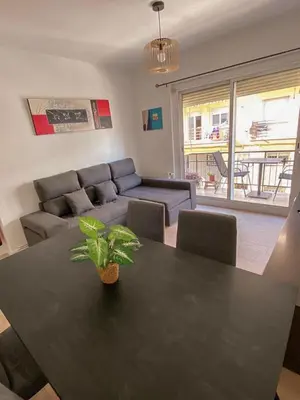 a living room with a table and a couch at Sitges Best Holidays Apartment in Sitges
