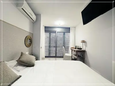 a bedroom with a bed and a desk and a window at FIRA GRAN VIA II in Hospitalet de Llobregat