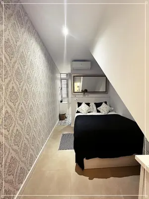 a bedroom with a black bed and a wall at FIRA GRAN VIA II in Hospitalet de Llobregat