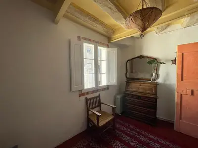 a room with a chair and a tv and a window at Original duplex in the center of Barcelona in Barcelona