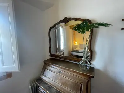 a mirror on top of a wooden dresser with a vase at Original duplex in the center of Barcelona in Barcelona