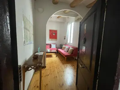 a hallway with a living room with a red couch at Original duplex in the center of Barcelona in Barcelona