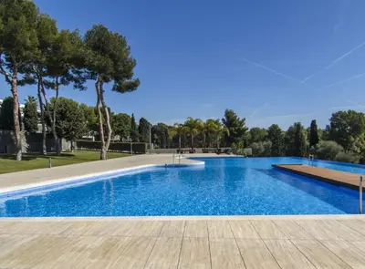 a swimming pool with blue water and trees at Duplex vistas mar con piscina in Sant Pere de Ribes