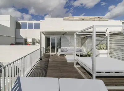 a balcony with white furniture on a house at Duplex vistas mar con piscina in Sant Pere de Ribes