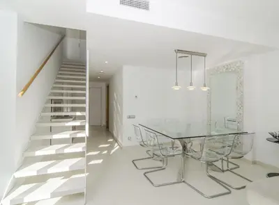 a dining room with a glass table and a staircase at Duplex vistas mar con piscina in Sant Pere de Ribes