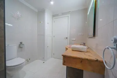 a white bathroom with a toilet and a sink at HomeHolidaysRentals Anais - Costa Barcelona in Pineda de Mar