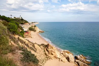 a beach next to the ocean with a lighthouse on a cliff at Holiday home in Calella de la Costa 3641 in Calella