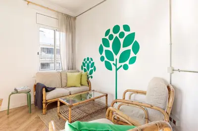 a living room with chairs and a tree stenciled on the wall at Eulalias Lodges Barcelona in Barcelona