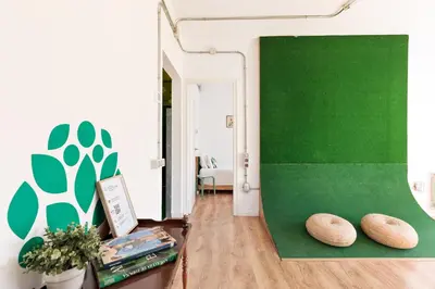 a room with a green wall and two pillows on the floor at Eulalias Lodges Barcelona in Barcelona