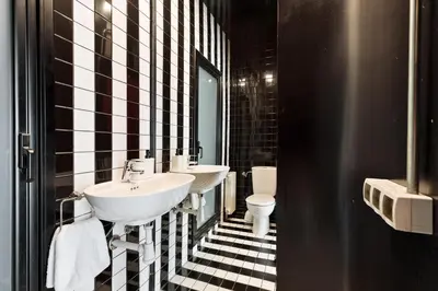 a black and white bathroom with two sinks and a toilet at Eulalias Lodges Barcelona in Barcelona