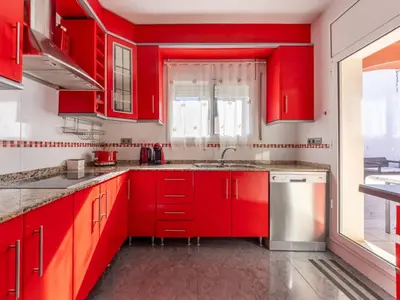 a red kitchen with red cabinets and a sink at Holiday Home Villa Rosales by Interhome in Gornal