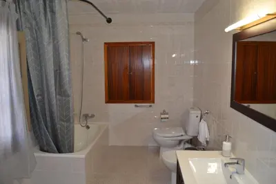 a bathroom with a toilet and a tub and a sink at Casa Cal Tòfol in Font-Rubí