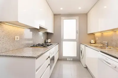 a kitchen with white cabinets and a stove top oven at Enjoy Apartments Calle Paris Super Stylish in Barcelona
