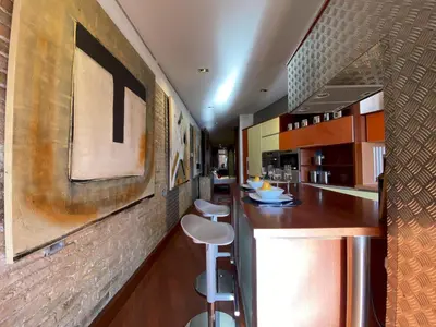 a kitchen with a bar with two stools in it at Luminous Designer Loft Style Apt Eixample Views By MyRentalHost in Barcelona