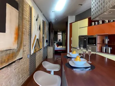 a kitchen with a long wooden table with white chairs at Luminous Designer Loft Style Apt Eixample Views By MyRentalHost in Barcelona
