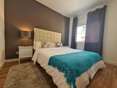 a bedroom with a large bed with a blue blanket at WALK to CAMP NOU - Wi-Fi AC 3 Bed by MyRentalHost in Hospitalet de Llobregat