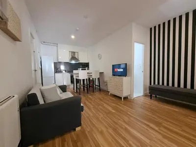 a living room with a couch and a television at WALK to CAMP NOU - Wi-Fi AC 3 Bed by MyRentalHost in Hospitalet de Llobregat