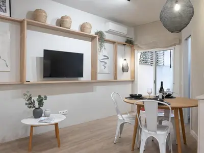 a dining room with a table and chairs and a tv at ´Vicens Gem´ Private terrace HS Wi-Fi in Gracia by MyRentalHost in Barcelona