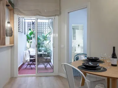 a kitchen and dining room with a table and a glass door at ´Vicens Gem´ Private terrace HS Wi-Fi in Gracia by MyRentalHost in Barcelona