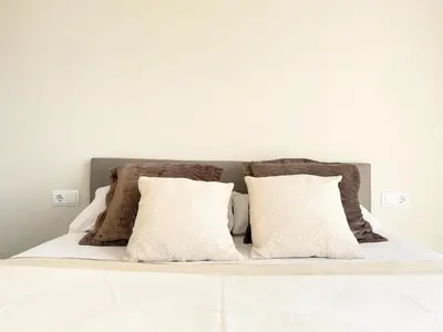a white bed with two pillows on top of it at Atico Isabel in Castelldefels