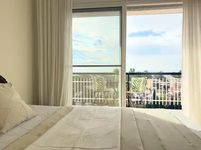 a bedroom with a bed and a large window at Atico Isabel in Castelldefels