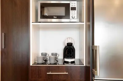 a coffee maker in a cupboard with a microwave at El balcón de Sagrada Familia in Barcelona