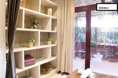 a room with white shelves with plants and a window at Family apartment Plaza España in Barcelona