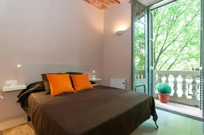 a bedroom with a bed with orange pillows and a balcony at Family apartment Plaza España 2 in Barcelona