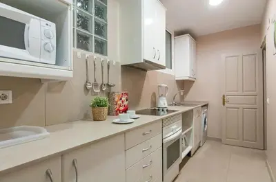 a kitchen with white cabinets and a counter top at Family apartment Plaza España 2 in Barcelona