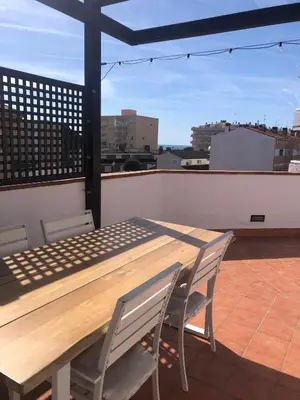 a wooden table and chairs on top of a roof at The White Lilies in Pineda de Mar