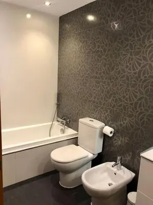 a bathroom with a toilet and a sink and a tub at The White Lilies in Pineda de Mar