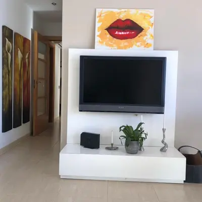 a flat screen tv on a wall in a living room at The White Lilies in Pineda de Mar