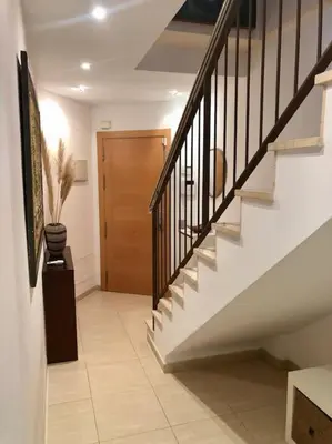 a hallway with stairs and a wooden door at The White Lilies in Pineda de Mar