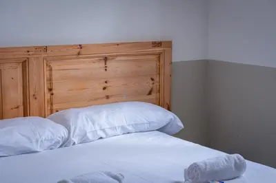 a bed with white sheets and a wooden headboard at Verdi 254 in Barcelona