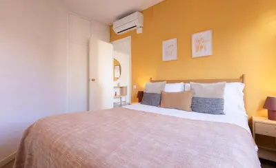 a bedroom with a large bed with yellow walls at Stay U-nique Apartment Rossello II in Barcelona
