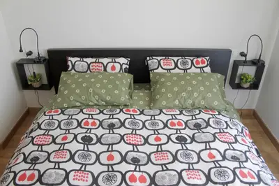 a bed with a black and white comforter and pillows at Apartment familiar in Barcelona