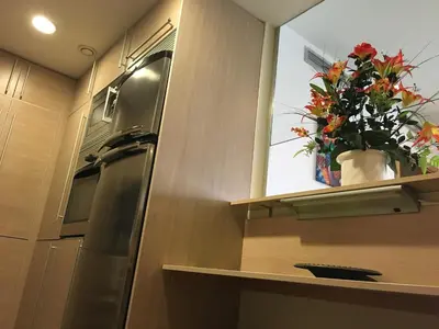 a kitchen with a refrigerator and a window with flowers at Apartment familiar in Barcelona