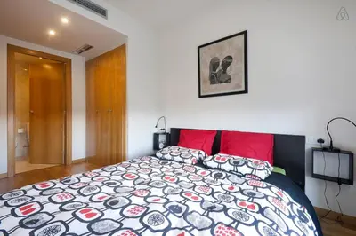 a bedroom with a large bed with red pillows at Apartment familiar in Barcelona