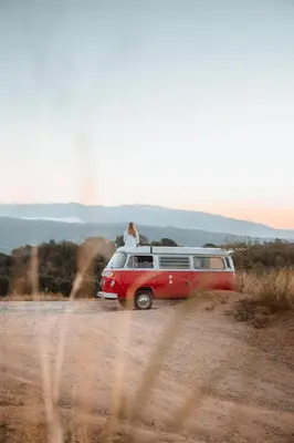 a person is sitting on top of a van at Retro VW Kombi T2 Campervan in Hospitalet de Llobregat