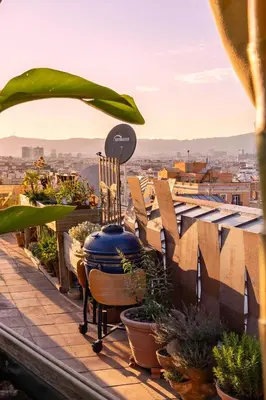 a balcony with potted plants and a view of a city at Apartment with Terrace Views of BCN in Barcelona