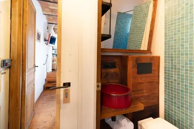 a bathroom with a toilet and a red bucket at Apartment with Terrace Views of BCN in Barcelona