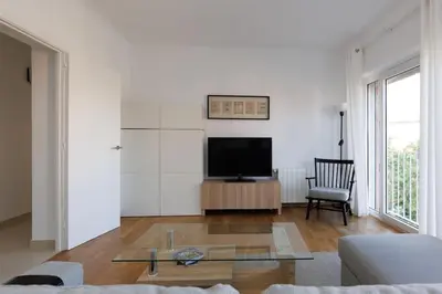 a living room with a couch and a tv at Housalia Casa del Mar en Vila Olímpica in Barcelona