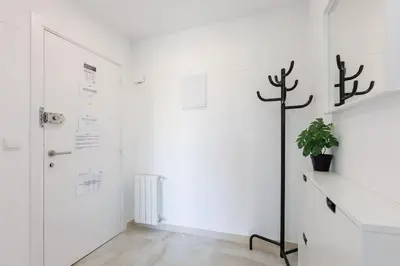 a white hallway with a door and a potted plant at Housalia Casa del Mar en Vila Olímpica in Barcelona