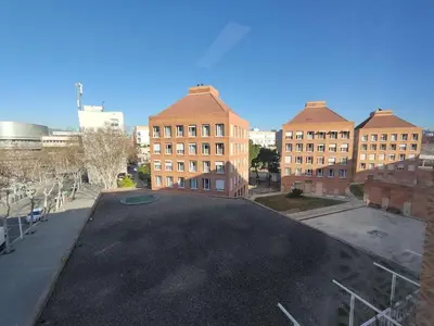 an empty parking lot in front of brick buildings at Housalia Casa del Mar en Vila Olímpica in Barcelona