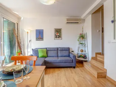 a living room with a blue couch and a table at Carmen Apartment by Hello Homes Sitges in Sitges