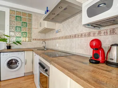 a kitchen with a sink and a washing machine at Carmen Apartment by Hello Homes Sitges in Sitges