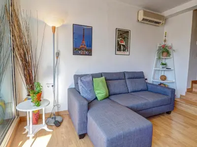 a living room with a blue couch and a table at Carmen Apartment by Hello Homes Sitges in Sitges