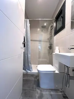 a white bathroom with a toilet and a sink at Studio Sagrada Familia in Barcelona