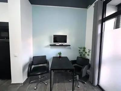 a room with a table and chairs and a tv on a wall at Studio Sagrada Familia in Barcelona